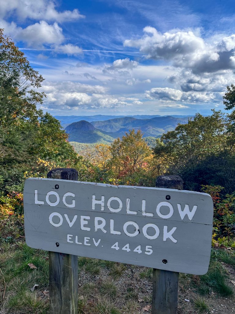 Log Hollow Overlook sign in autumn in the Blue Ridge Mountains off the Blue Ridge Parkway with fall foliage behind the sign